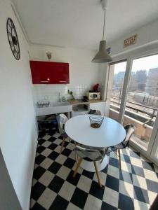 una cocina con mesa y sillas en un suelo a cuadros en Proche tram A: 3 personnes, balcon, wifi gratuit, en Grenoble