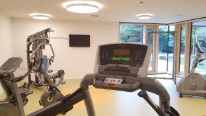 einen Fitnessraum mit zwei Heimtrainern und einem Laufband in der Unterkunft Hotel Knoblauch in Friedrichshafen