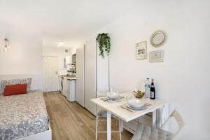 a white living room with a table and a kitchen at Estudio Torres del Sol in Playa de las Americas