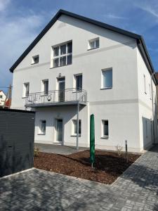 ein weißes Gebäude mit einem Balkon an der Seite in der Unterkunft Zum Rosental in Rötha