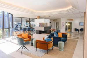 a living room with couches and chairs and a table at Thalazur Ouistreham - Hôtel & Spa in Ouistreham