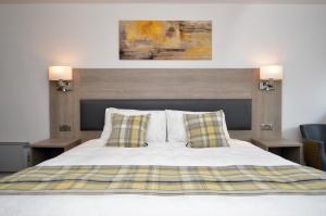 a bedroom with a bed with two night stands and two lamps at Fyne Rooms in Tighnabruaich