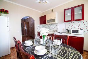 uma cozinha com uma mesa com cadeiras e uma sala de jantar em AB Apart Business 1b50 em Astana