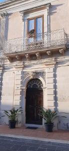 Casa Barocco siciliano في Canicattini Bagni: مبنى به باب خشبي وبه مصنوعين خزاف
