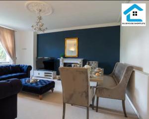 sala de estar con mesa y pared azul en Three Bedroom Apartment At Bluehouse Short Lets Brighton With Garden Family Leisure, en Brighton & Hove