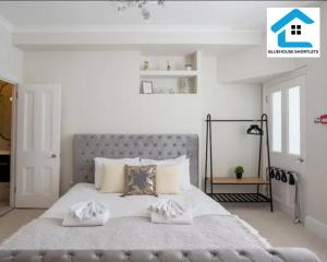 1 dormitorio con 1 cama grande y paredes blancas en Three Bedroom Apartment At Bluehouse Short Lets Brighton With Garden Family Leisure, en Brighton & Hove