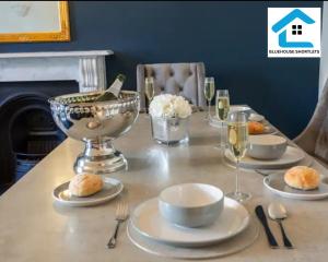 a table with plates and glasses of wine on it at Three Bedroom Apartment At Bluehouse Short Lets Brighton With Garden Family Leisure in Brighton & Hove