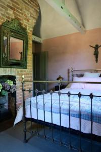 ein Schlafzimmer mit einem Bett und einem Kamin mit einem Spiegel in der Unterkunft Monastery Cottage in Rye