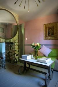 - un salon avec une table, des livres et un miroir dans l'établissement Monastery Cottage, à Rye