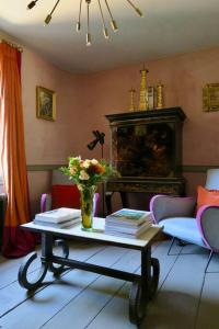 a living room with a table with a vase of flowers at Monastery Cottage in Rye