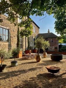 a courtyard with potted plants in front of a building at Monastery Cottage in Rye