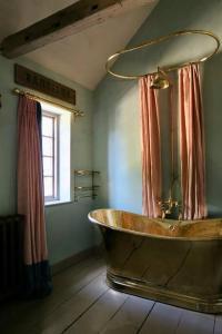 a bath tub in a bathroom with a window at Monastery Cottage in Rye