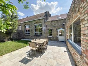 a patio with a table and chairs in front of a brick building at STKE - holiday home for 8 in Veurne