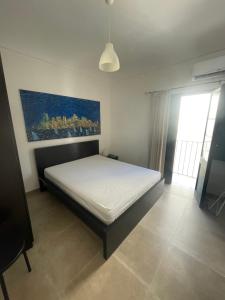 a bedroom with a bed and a painting on the wall at Zohra in Castellammare del Golfo