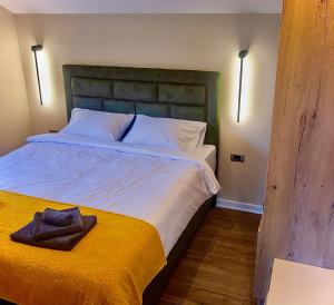 a bedroom with a bed with a towel on it at Aqua Casa in Vrnjačka Banja