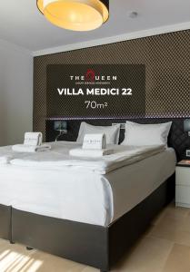 uma cama grande num quarto com uma placa na parede em The Queen Luxury Apartments - Villa Medici no Luxemburgo