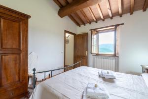 a bedroom with a white bed with a window at Pugnano Alto -appartamento Castagna in Lisciano Niccone