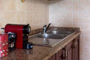 a kitchen counter with a stainless steel sink at Pugnano Alto -appartamento Castagna in Lisciano Niccone +16 photos