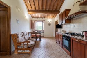 una cocina con sofá y mesa. en Pugnano Alto -appartamento Castagna, en Lisciano Niccone
