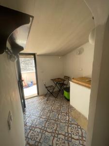 a room with a kitchen with a table and a floor at Zohra in Castellammare del Golfo