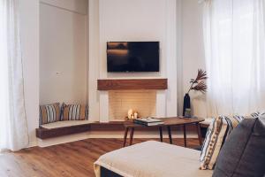 a living room with a fireplace with a tv above it at The Repose Aesthetic Apt. R1 in Heraklio Town