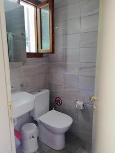 Łazienka z białą toaletą i umywalką w obiekcie Hotel Erato w mieście Chorefto