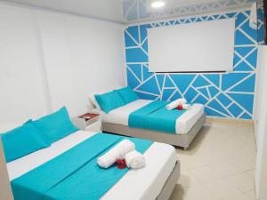 ein Schlafzimmer mit 2 Betten und einem Bildschirm in der Unterkunft Apartamento cerca al Centro Histórico en Edificio frente a la playa A-3-5 in Cartagena de Indias
