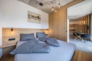 a bedroom with a blue bed and a dining room at Thalerhof Naturae Oasis Ritten in Auna di Sotto