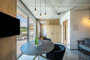 a room with a table and chairs and a television at Thalerhof Naturae Oasis Ritten in Auna di Sotto