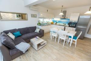 a living room with a couch and a table and a kitchen at VILLA DONNA in Pridraga