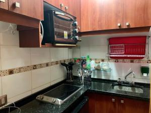 cocina con fregadero y microondas en Departamento en Playa Acapulco viña del mar, en Viña del Mar