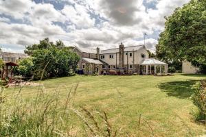 ein großes weißes Haus mit einem großen Garten in der Unterkunft Meadow Cottage in Bicester