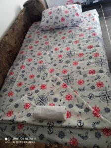 a bed with a bedspread with flowers on it at apartman Dragic in Budva