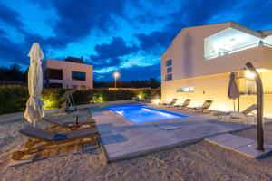 a villa with a swimming pool at night at VILLA DONNA in Pridraga