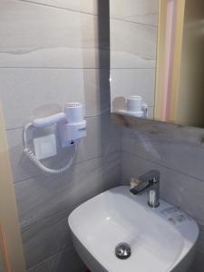 W łazience znajduje się biała umywalka i lustro. w obiekcie Hotel Erato w mieście Chorefto
