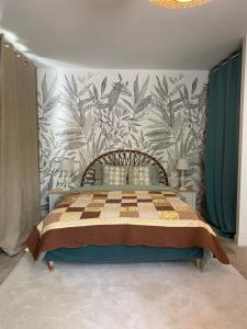 ein Schlafzimmer mit einem großen Bett mit Blumentapete in der Unterkunft Pavillon époque Napoléon III in Maurecourt