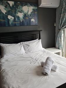 ein weißes Bett mit einem Handtuch darüber in der Unterkunft 17 Isikhulu in Umdloti + 16 Fotos
