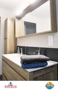 a bathroom with a sink and a mirror at Little America - Appart Hôtel 3km Futuroscope in Jaunay-Marigny