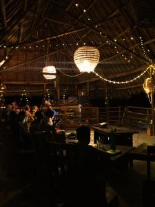 a group of people sitting at a restaurant with lights at La Fontana Zanzibar in Kendwa