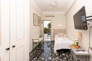 a small room with a bed and a tv on the wall at Boutique Hotel Oriola in Cala de Sant Vicenc