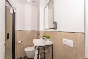 a bathroom with a sink and a toilet and a mirror at Boutique Hotel Oriola in Cala de Sant Vicenc