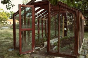 a greenhouse with glass doors in the grass at Ödevata Gårdshotell in Emmaboda