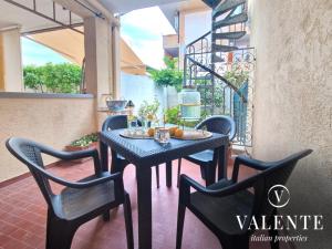 una mesa negra y sillas en un patio en Casa al Mare - Torre del Lago- Valente Italian Properties, en Torre del Lago Puccini