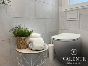 baño con aseo y mesa con planta en Casa al Mare - Torre del Lago- Valente Italian Properties, en Torre del Lago Puccini