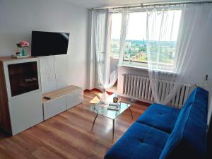 salon z niebieską kanapą i telewizorem w obiekcie Parkcity Chorzów w mieście Chorzów