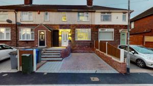 a brick house with cars parked in front of it at Redwood in Longton