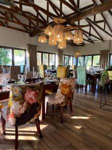 uma sala de jantar com mesa, cadeiras e lustres em Nut Grove Manor Boutique Hotel em White River