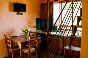 comedor con mesa y TV en Locanda Le Tre Sorelle, en Casal Velino