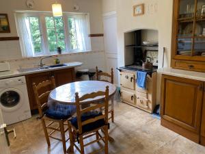 a kitchen with a table and chairs and a sink at Rectory Bungalow Holiday Apartment in Lower Brailes