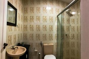 La salle de bains est pourvue d'une douche, de toilettes et d'un lavabo. dans l'établissement Apto central, com vista deslumbrante!, à Curitiba